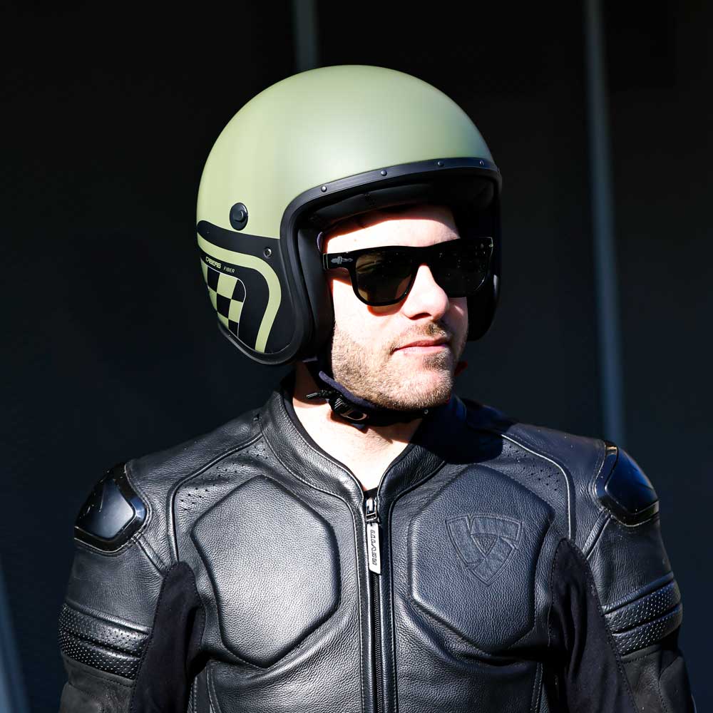 side fo biker wearing black and green open face freeride x motorbike helmet