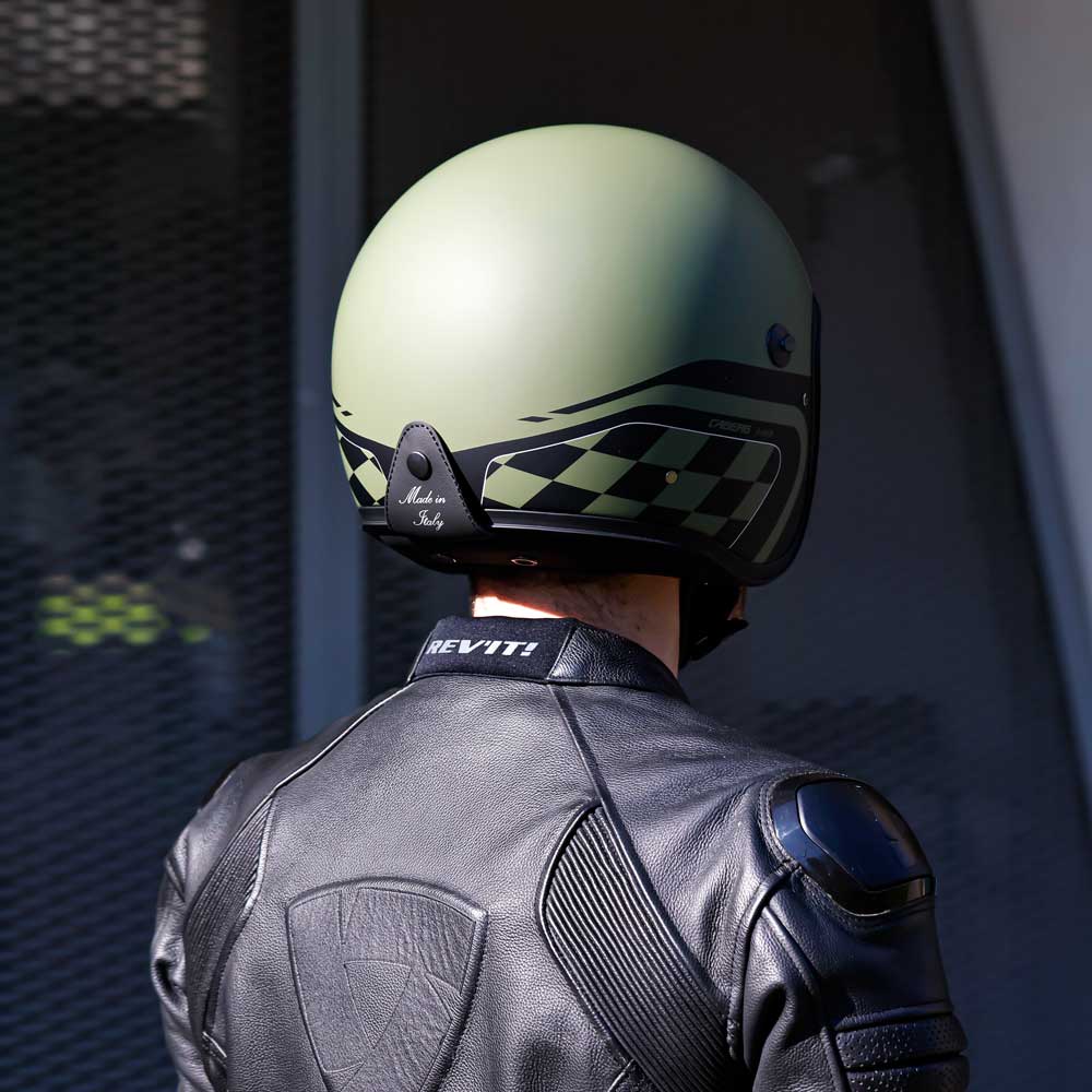 back of biker wearing black and military green open face motorbike helmet with made in italy tag