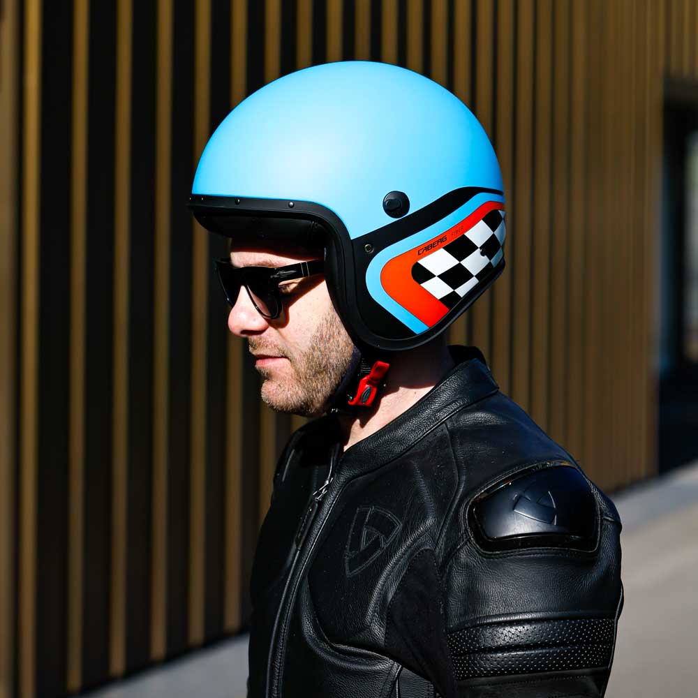 side of biker standing wearing matte blue, black and orange open face biker helmet for men