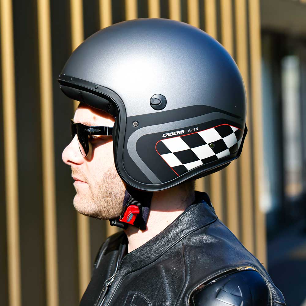 biker wearing grey gun metal open face helmet with chequered design on the side