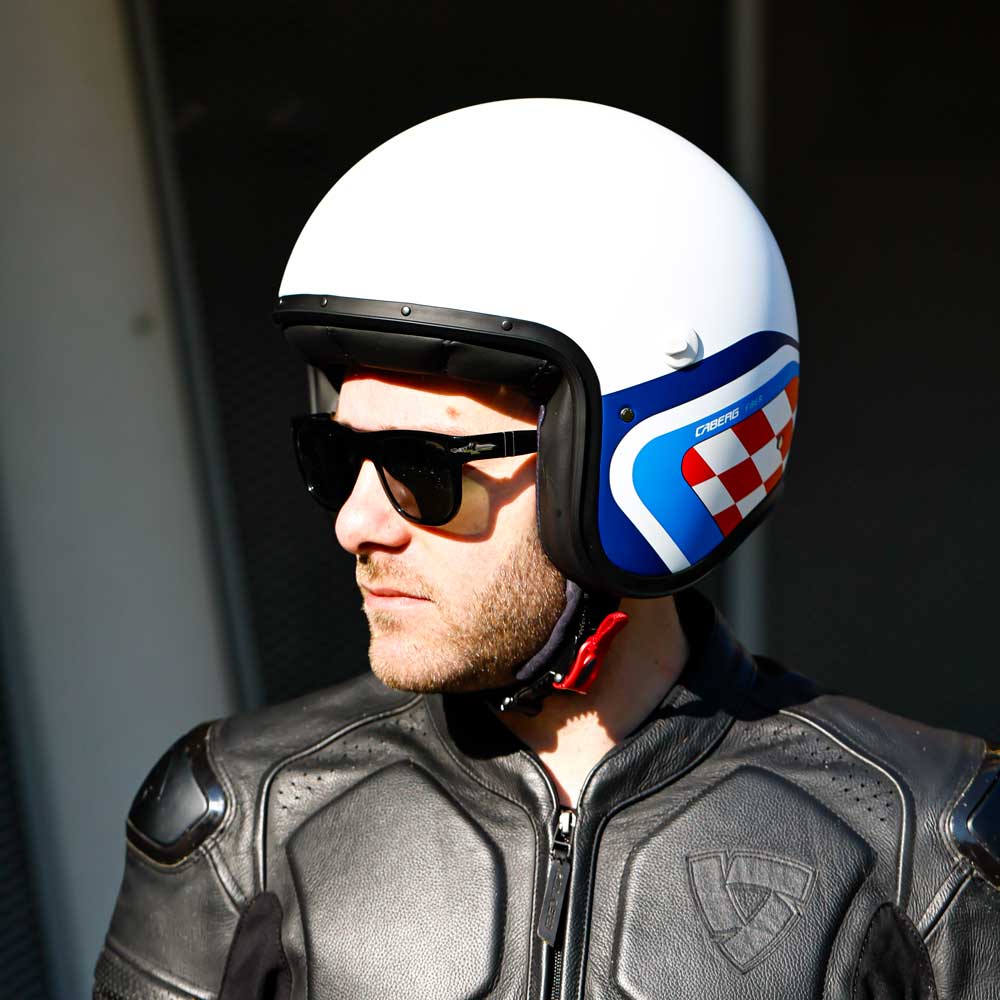 biker wearing matte white with blue and red design open face freeride x motorbike helmet