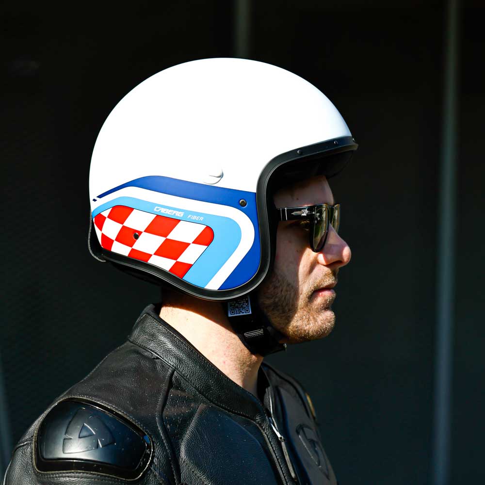 side view of biker wearing matte white motorbike helmet with blue and red design
