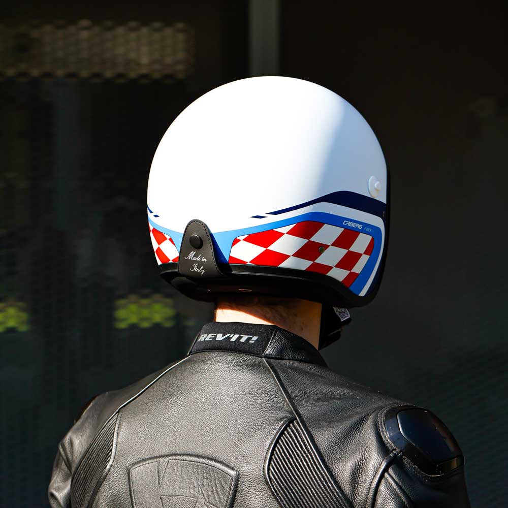 back of biker wearing matte white blue and red motorbike helmet