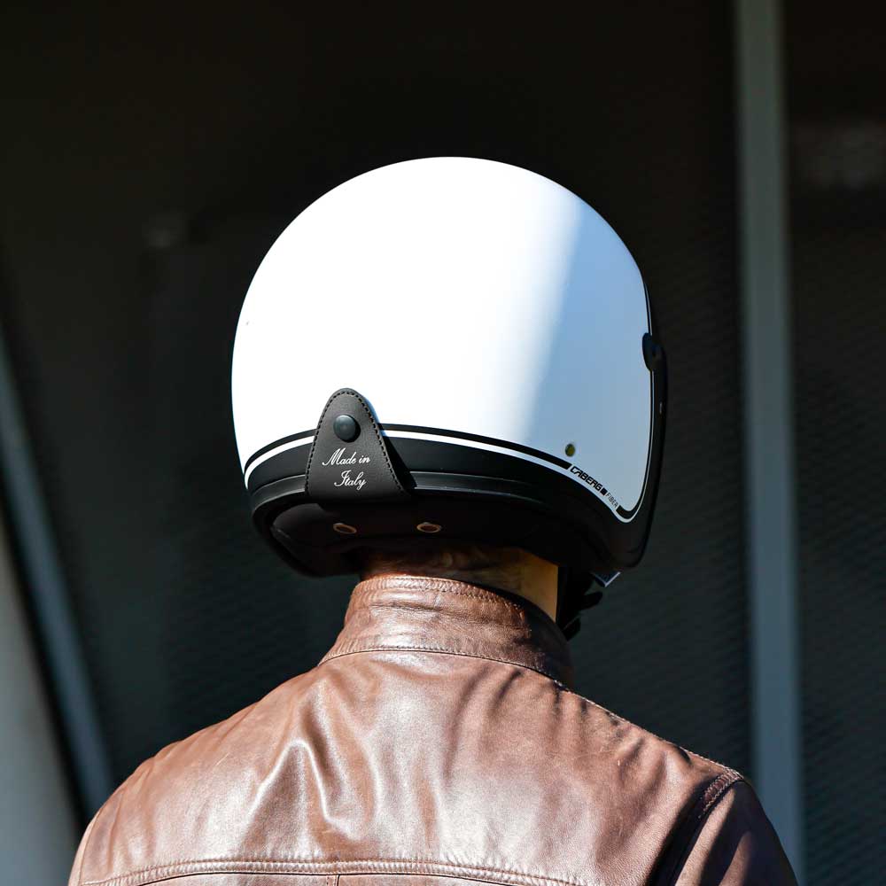 back of biker wearing matte white motorcycle helmet with black border design