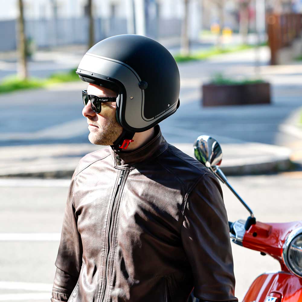 side of man wearing matte black and grey open face helmet with black sunglasses
