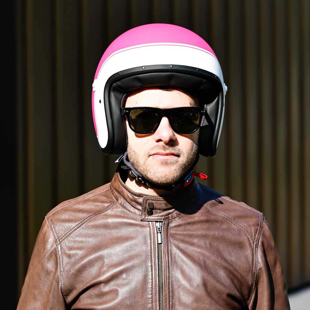 biker wearing pink and white open face helmet with sunglasses