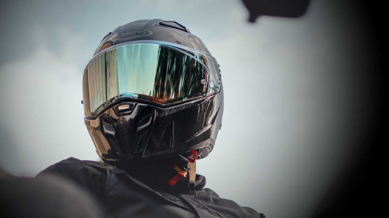 biker on motorbike wearing the black drift evo ii carbon motorbike helmet by caberg