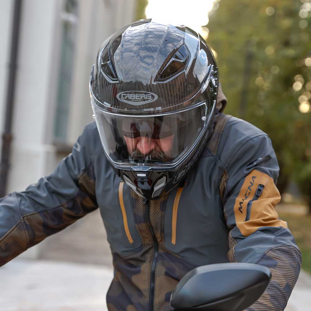 biker wearing black motorbike helmet with integrated sun visor