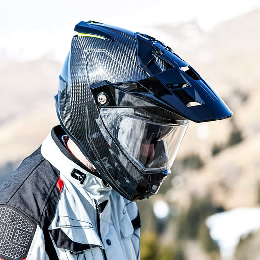biker wearing black adventure riding caberg helmet with peak in the mountains