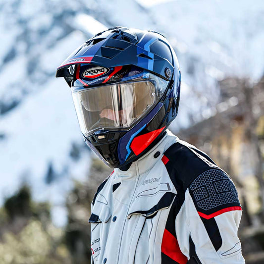 biker wearing blue and red tanami scram caberg motorbike helmet in the mountains