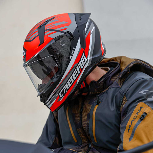 biker wearing black and red motorcycle helmet for men on motorbike