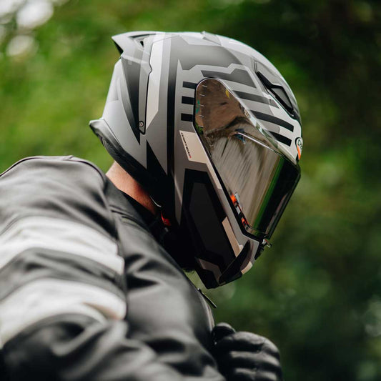 biker wearing black leather jacket for men with black and grey caberg motorbike helmet