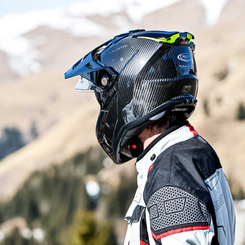 back of biker in the mountains looking away wearing the black caberg tanami full face motorbike helmet