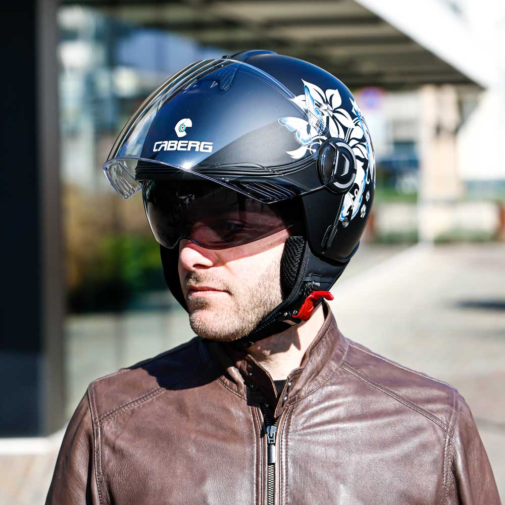 Man looking right with the clear visor lifted, emphasizing the inner sun visor and the right-side flower design.