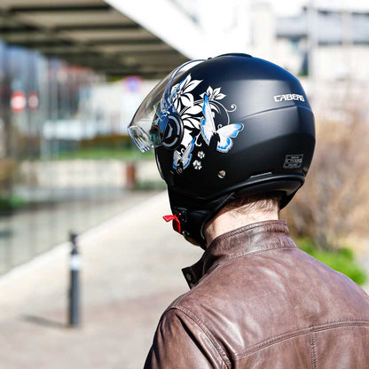 Rear view of a man wearing the helmet with the clear visor up, showing the full floral design across the back.